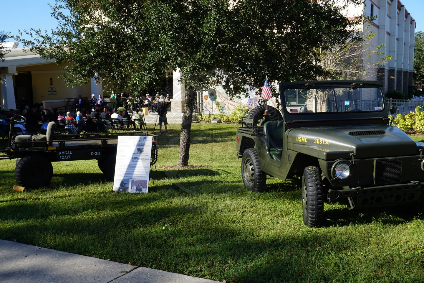 two military vehicles parked in grass area for display