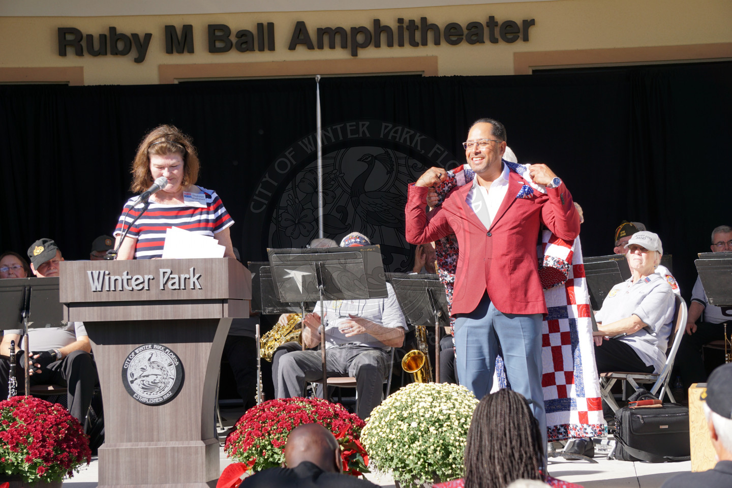 A veteran standing on stage accepting his quilt of valor