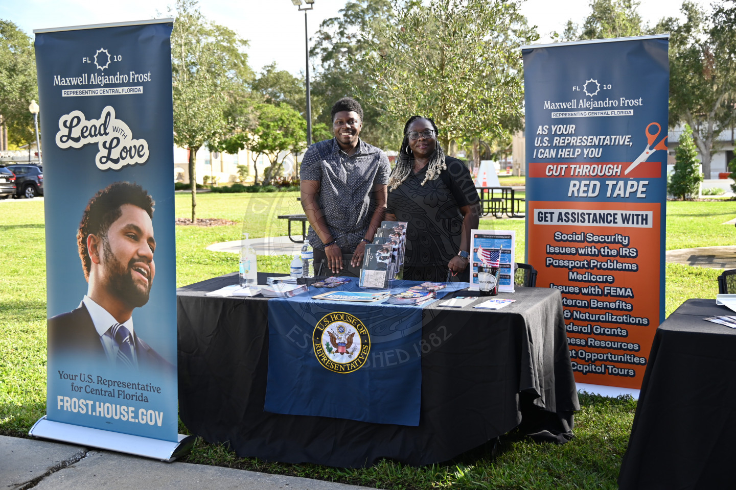A man and a lady standing behind a table with veteran information. 