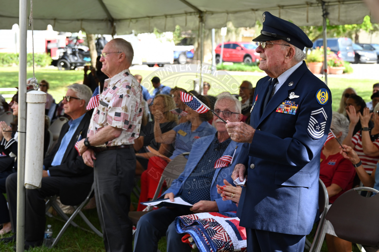 two veterans standing up and waving their flags. 