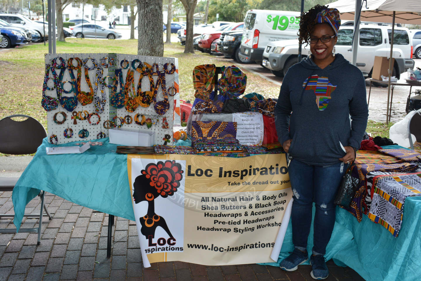 Female smiling in front of Loc Inspiration vendor booth