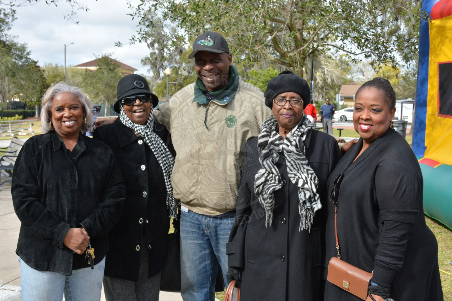 Group of one male and four female event attendees smiling