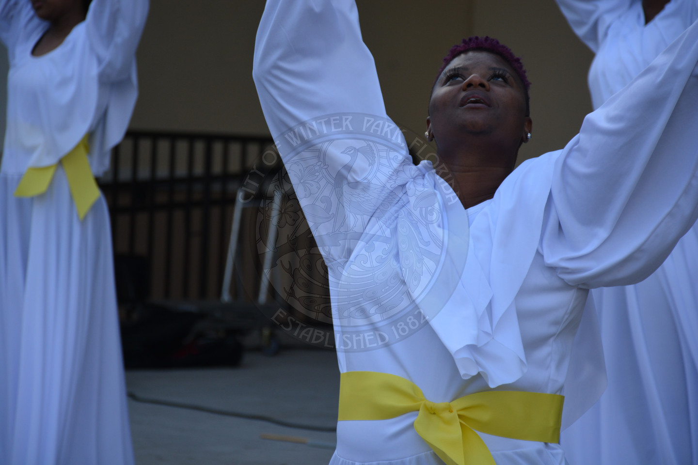 close up of female dancing with her arms up and her looking to the sky