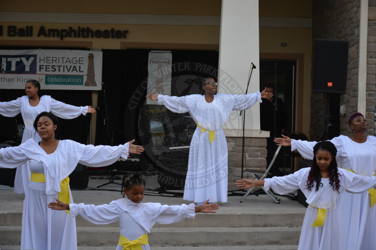 group photo of performers in flowy robes with their arms out to the side