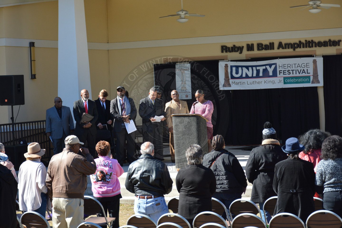 Wide shot of stage and attendees standing