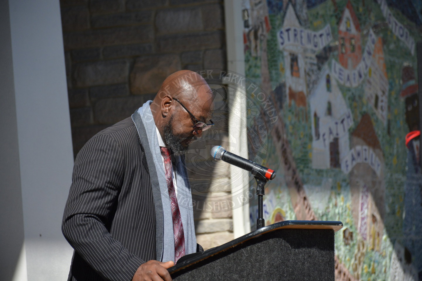 Gentlemen at the podium with his head looking down