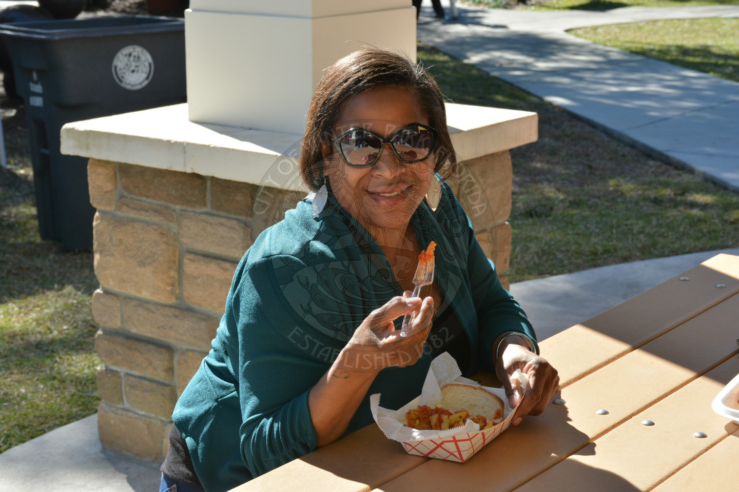 Female seated at picnic table enjoying her lunch