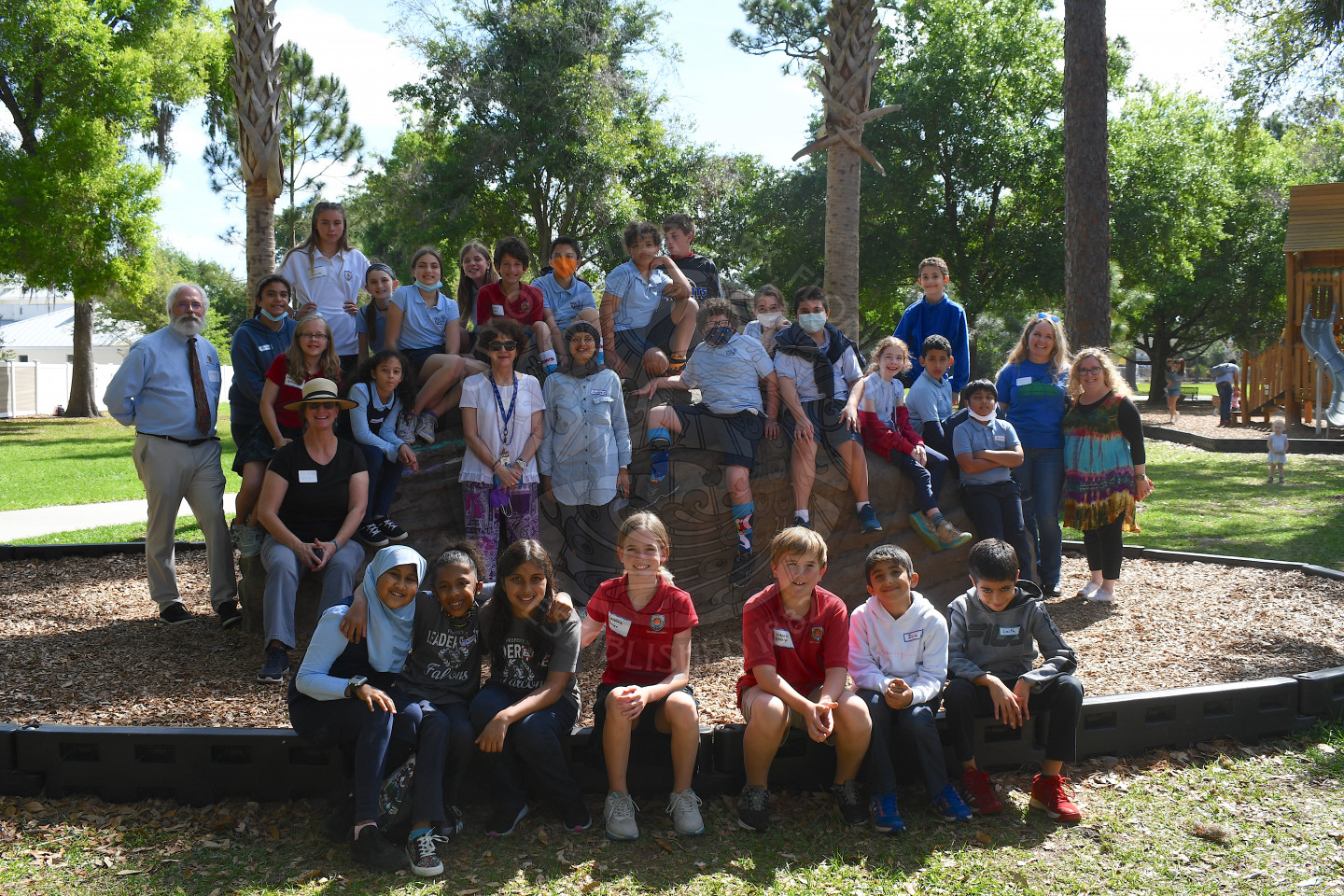 Group photo of 30 kids on a big rock