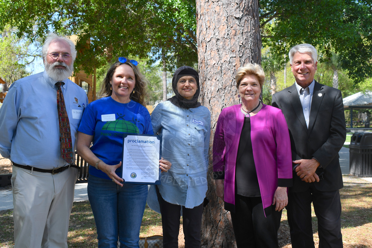 Men and women standing holding arbor day proclamation