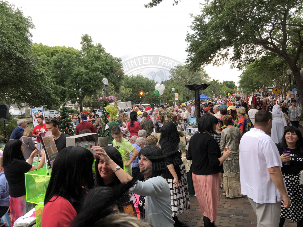 A shot of all the tables down park avenue with people standing around the table.