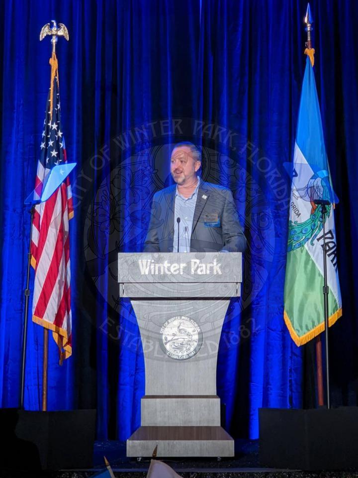 Justin Bermele, Advent Health Winter Park CEO, on stage behind the podium
