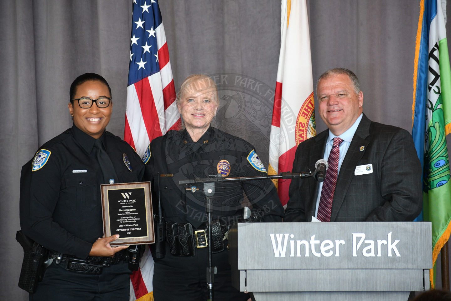 Women with employee of the year plaque with Deputy Chief Marcum and City Manager Randy Knight