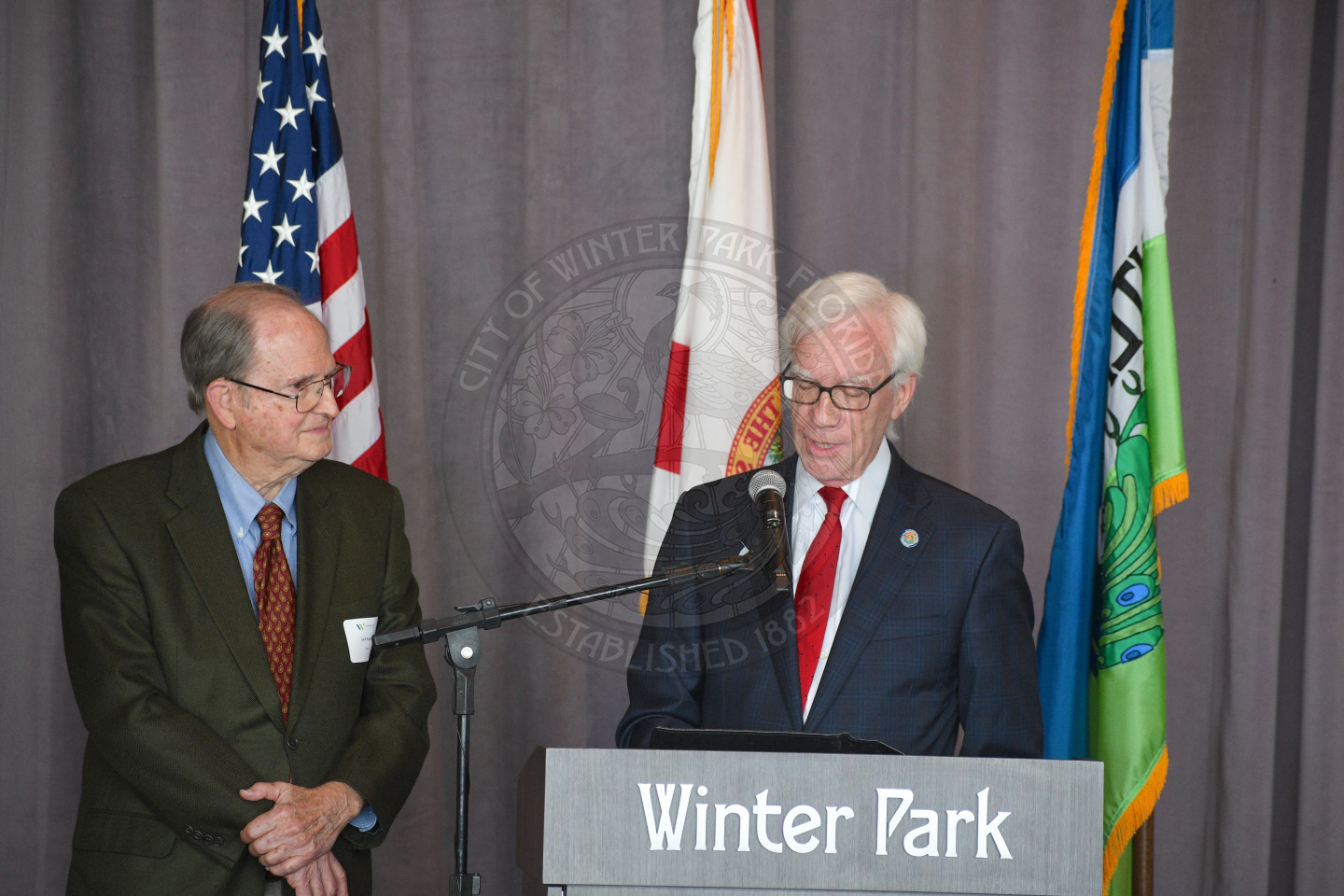 Mayor Phil Anderson talking into a microphone with reward recieptent standing next to him