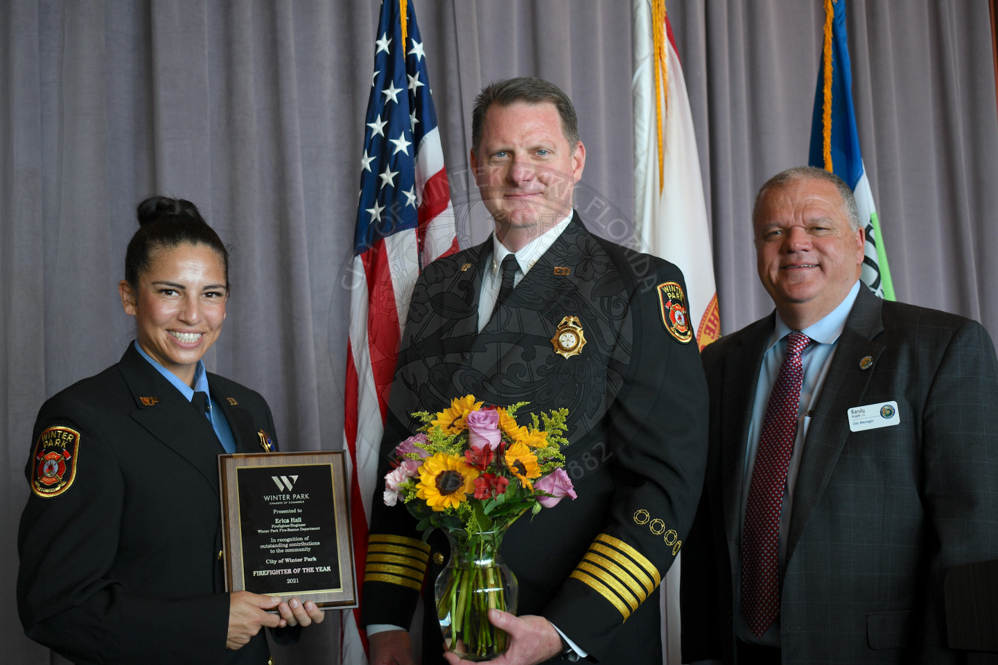 group photo of a women holidng employee of the year plaque with Fire Chief Hagedron and City Manager Randy Knight