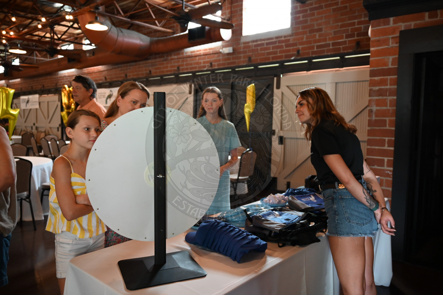 a table with prizes and a wheel to spin for guests.