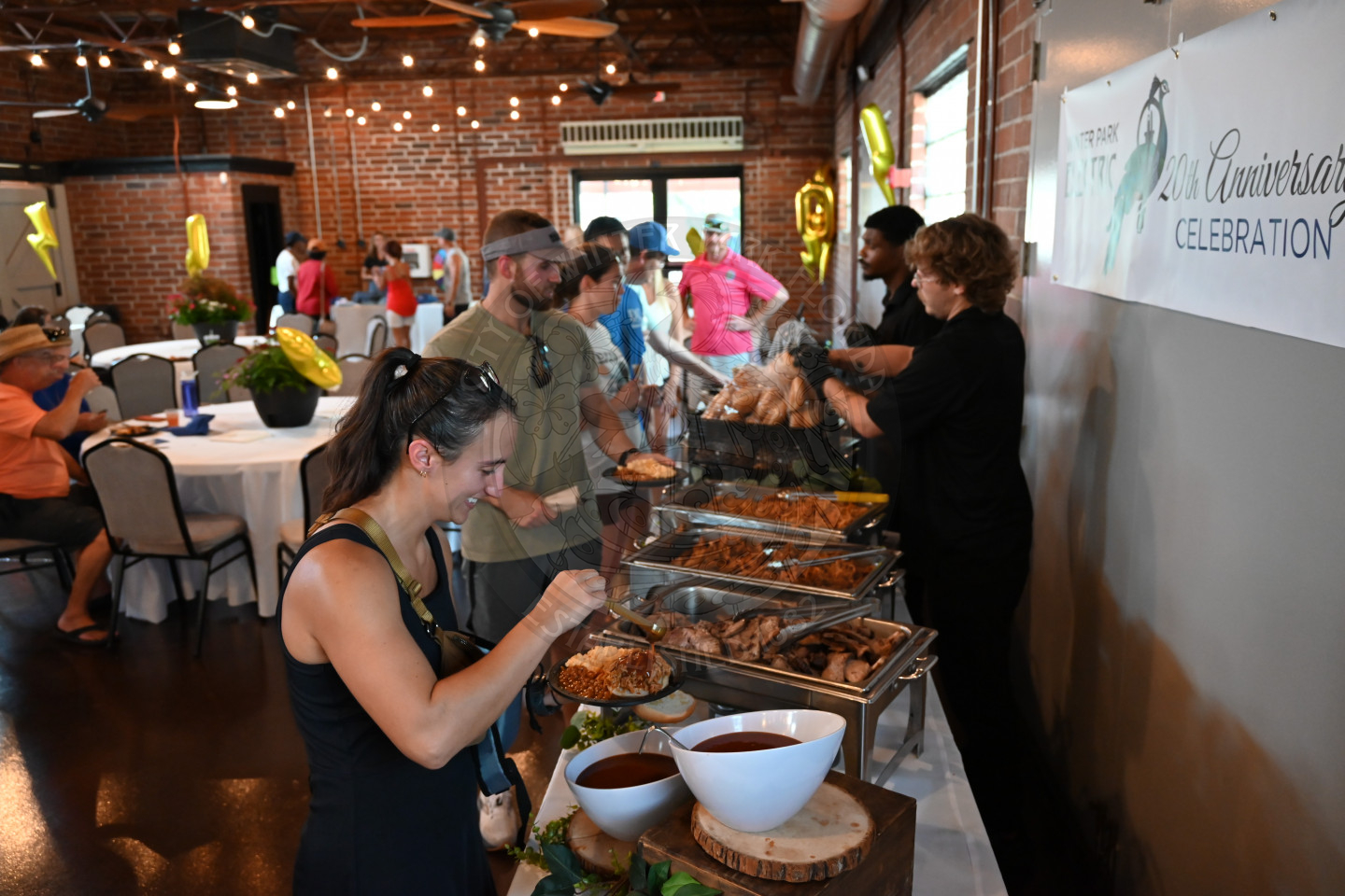 people standing in front of food line placing food on their plates.