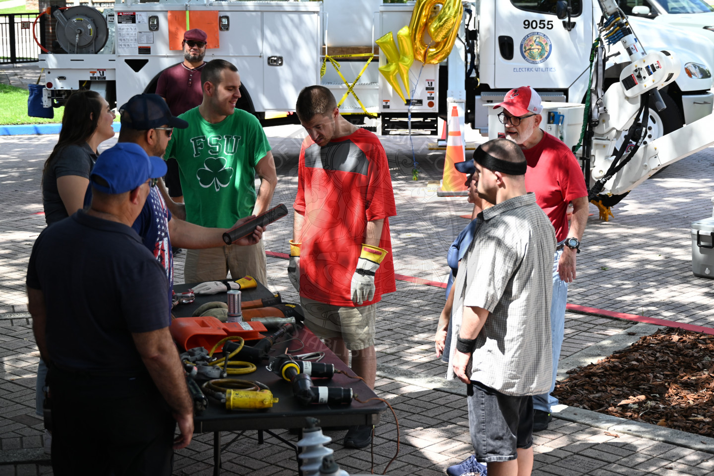 group of men looking at the table that has tools that the Electric Utility deparment uses