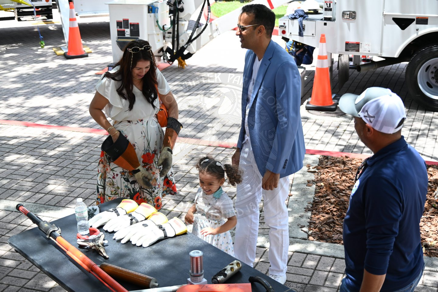 a family standing in front a table messing around with the adult gloves that are sitting on the table.