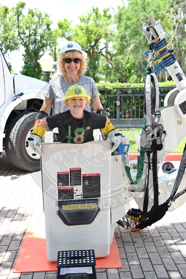 an older lady and her grandson inside of the bucket in a bucket truck.