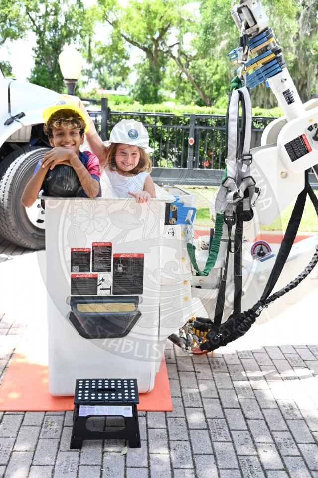 two kids inside the bucket of a bucket truck