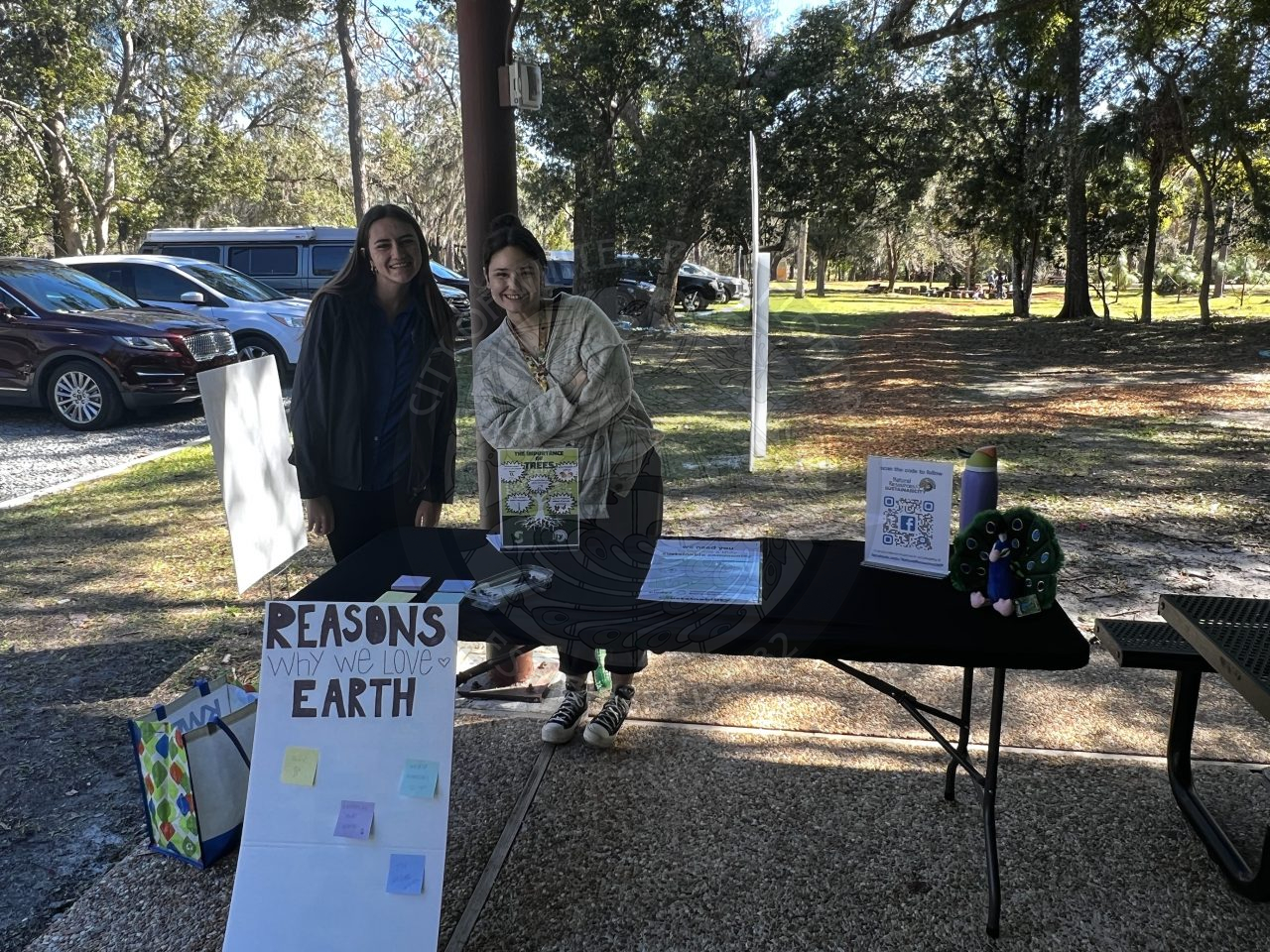 2 city staff members standing behind table with sustainability tips