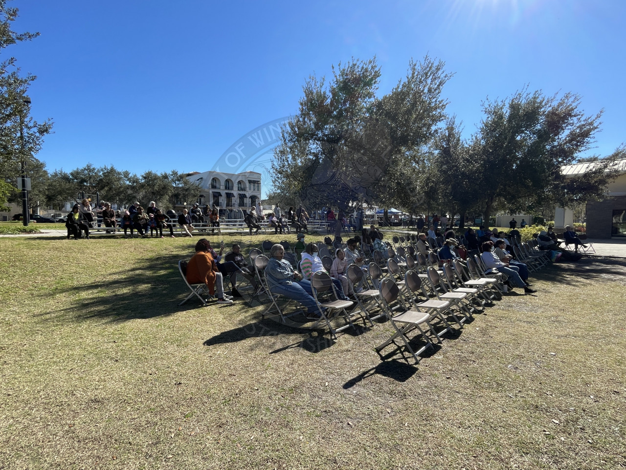 People sitting in chairs listening to a man talk on stage