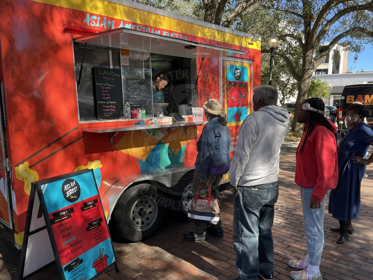 a food truck with people waiting in line