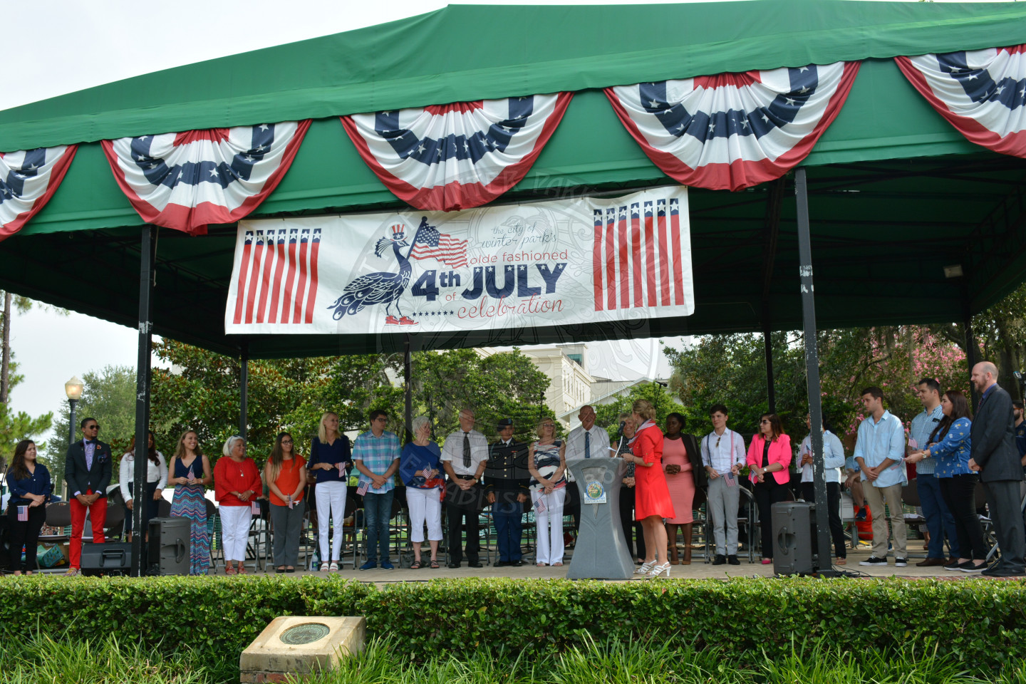 people getting sworn in as American citizens on stage in Central Park