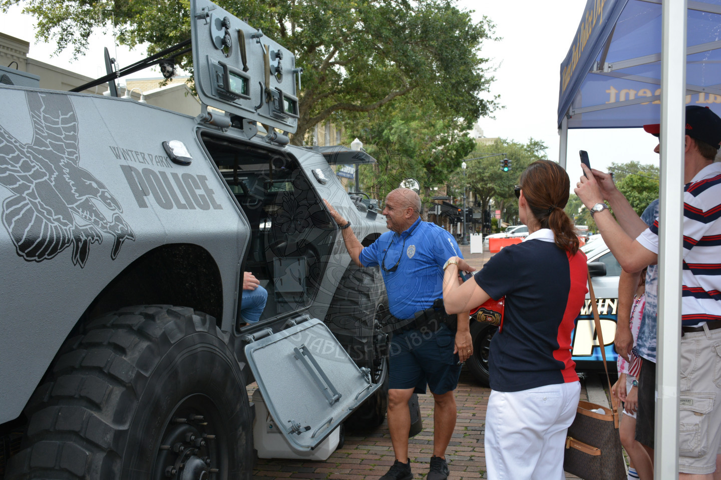 people standing around a police department tank