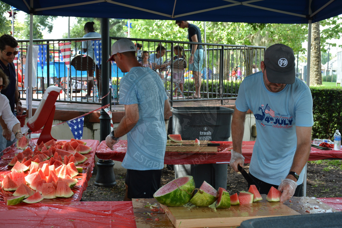 two city employees cutting watermelon