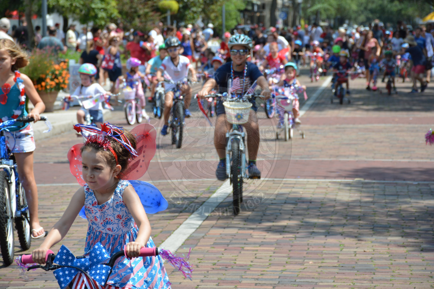 kids riding decorated bikes down park avenue