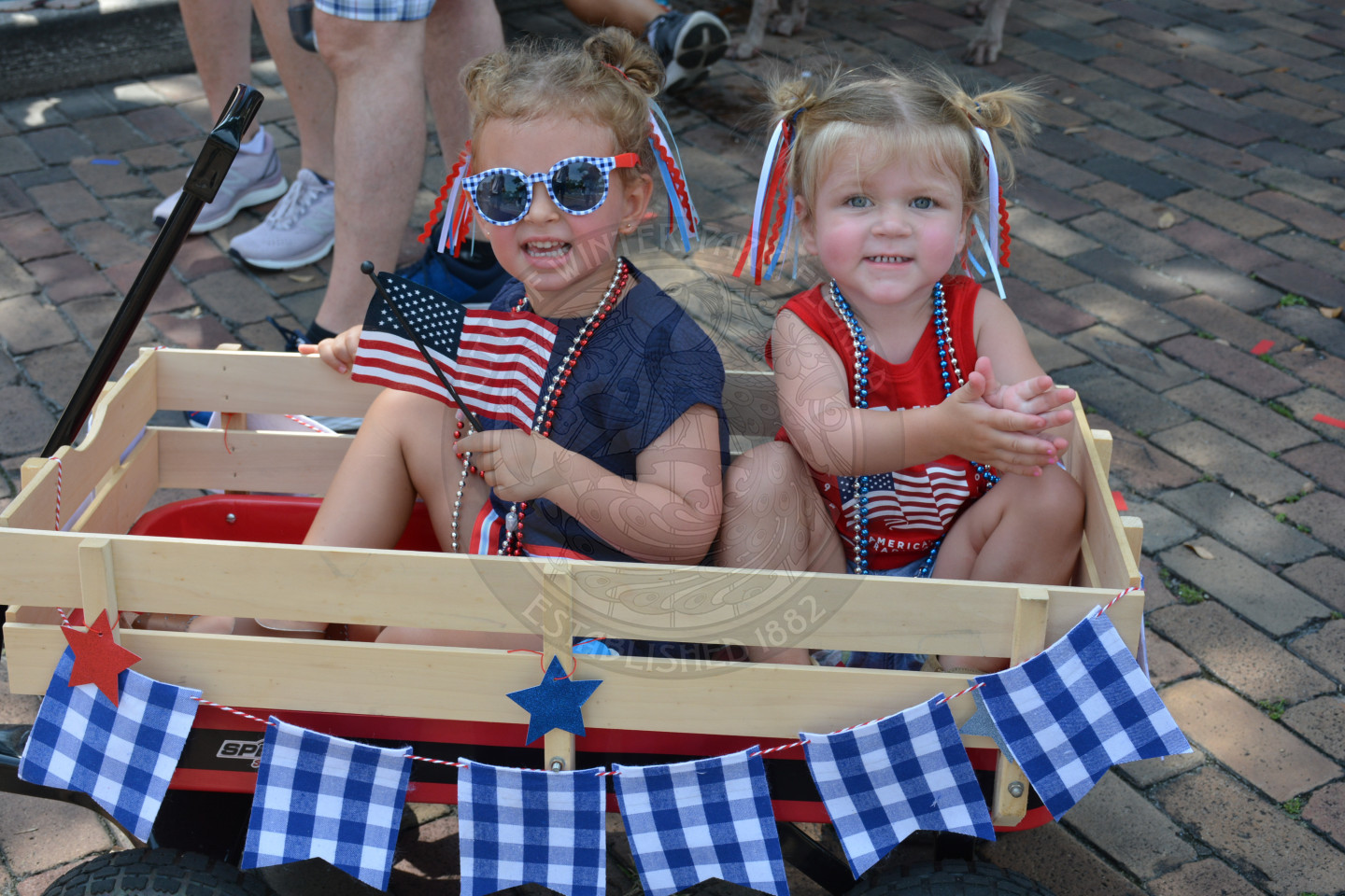 two girls dressed patriotically in a wagon