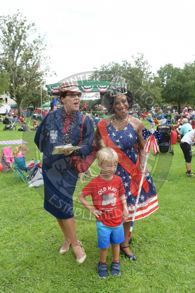 two characters from the Citizens of Yesteryear in costume with a little boy