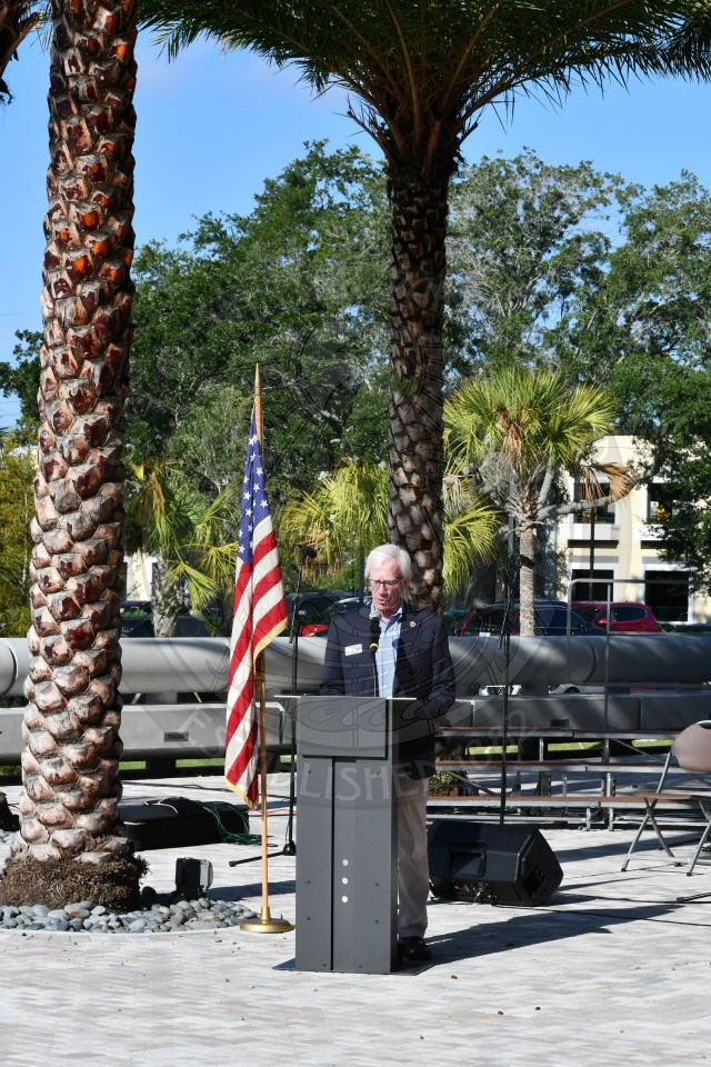 Mayor Phil Anderson speaking to event attendees standing behind a podium with the United States flag to his right.