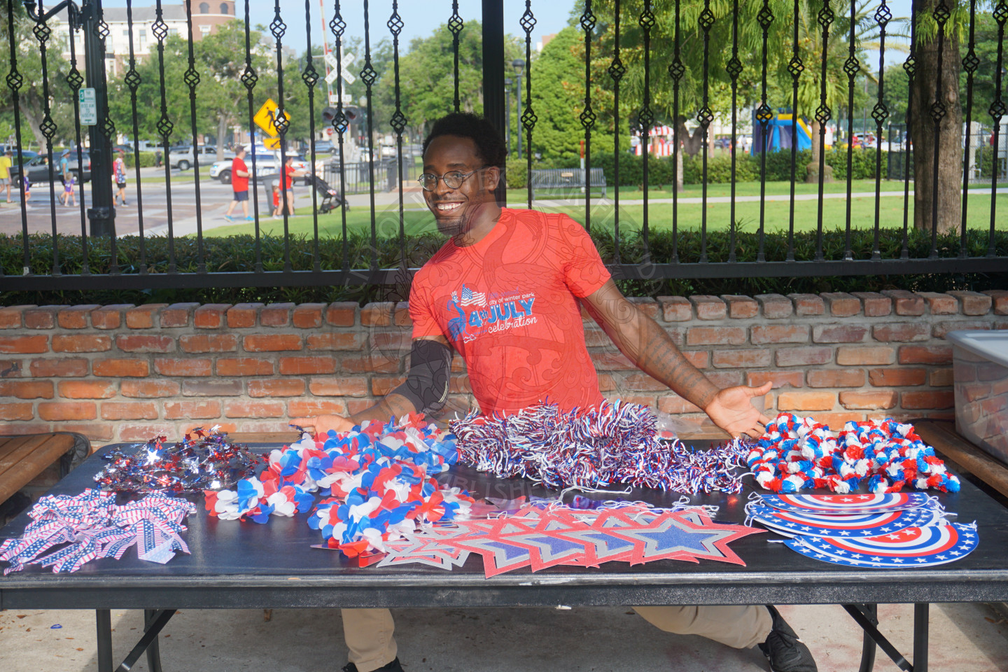 man sitting behind a 6-foot table with americana decorations