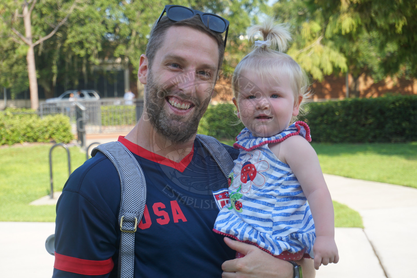 a man holding baby girl smiling at the camera