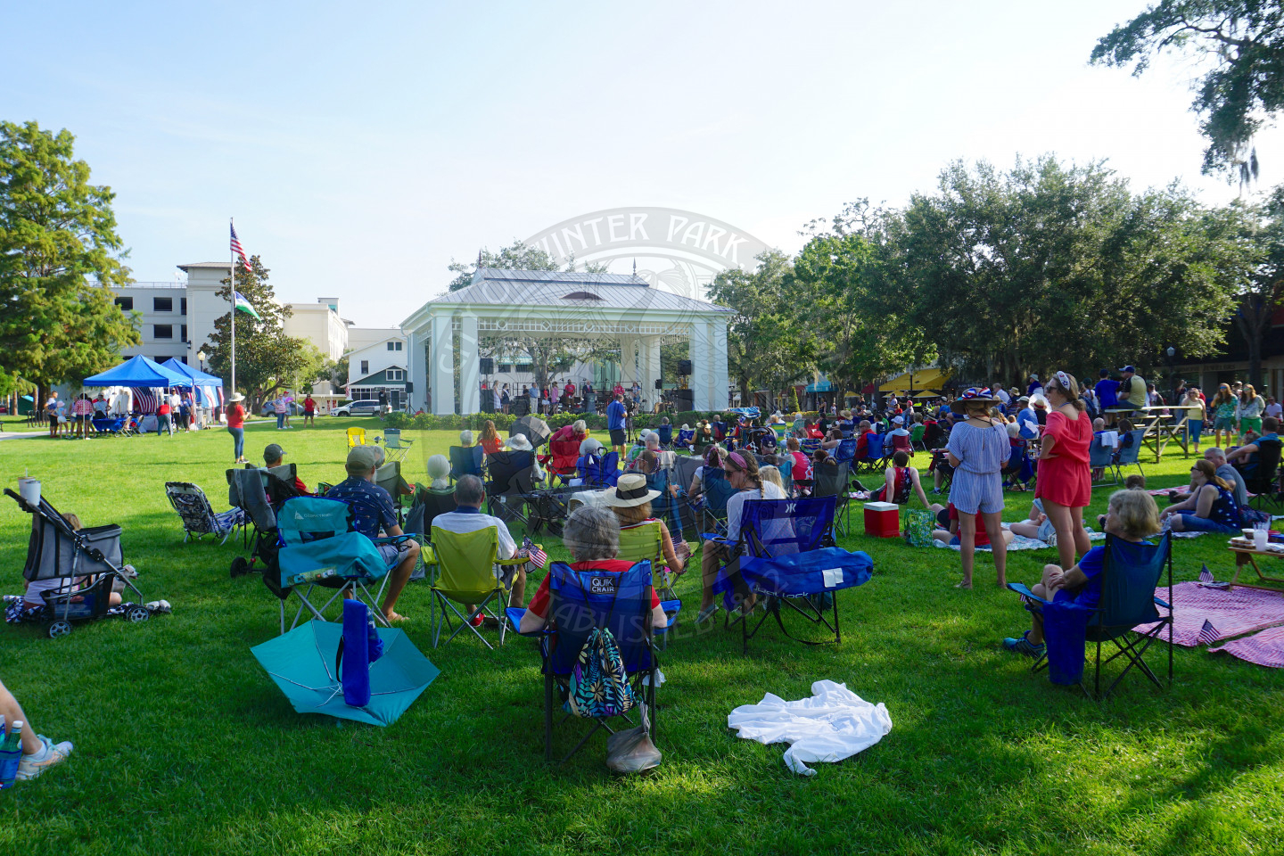 people sitting in lawn chairs at overlooking the stage