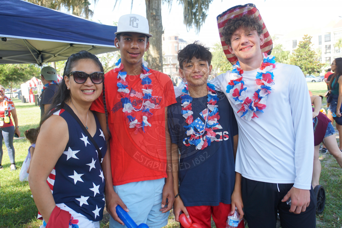 group of 3 boys and 1 woman smiling for the camera