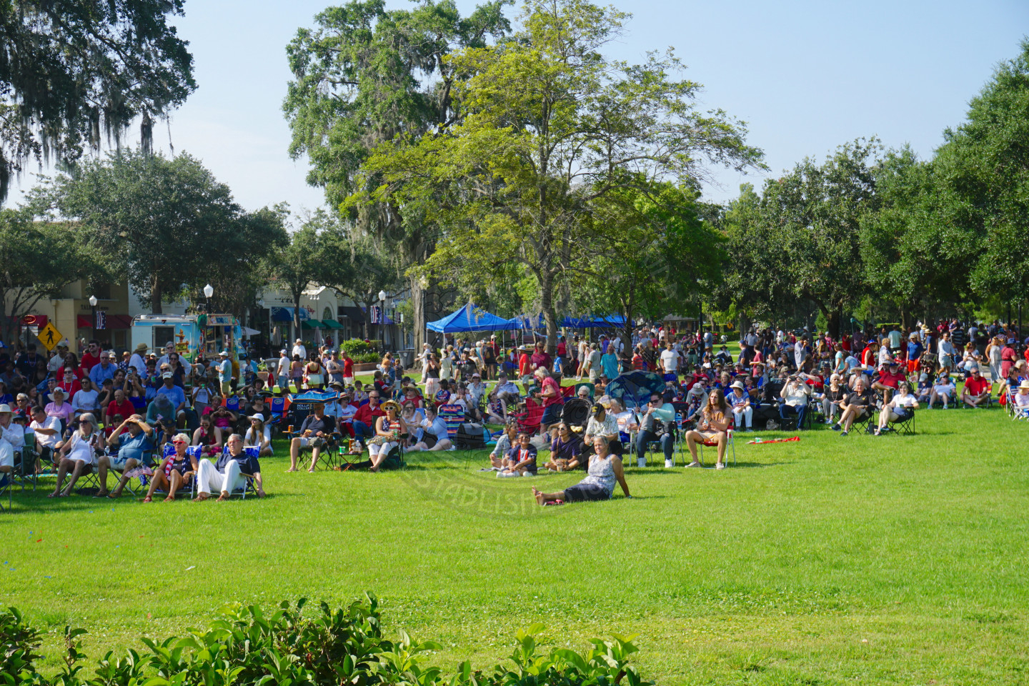 people sitting in lawn chairs at overlooking the stage