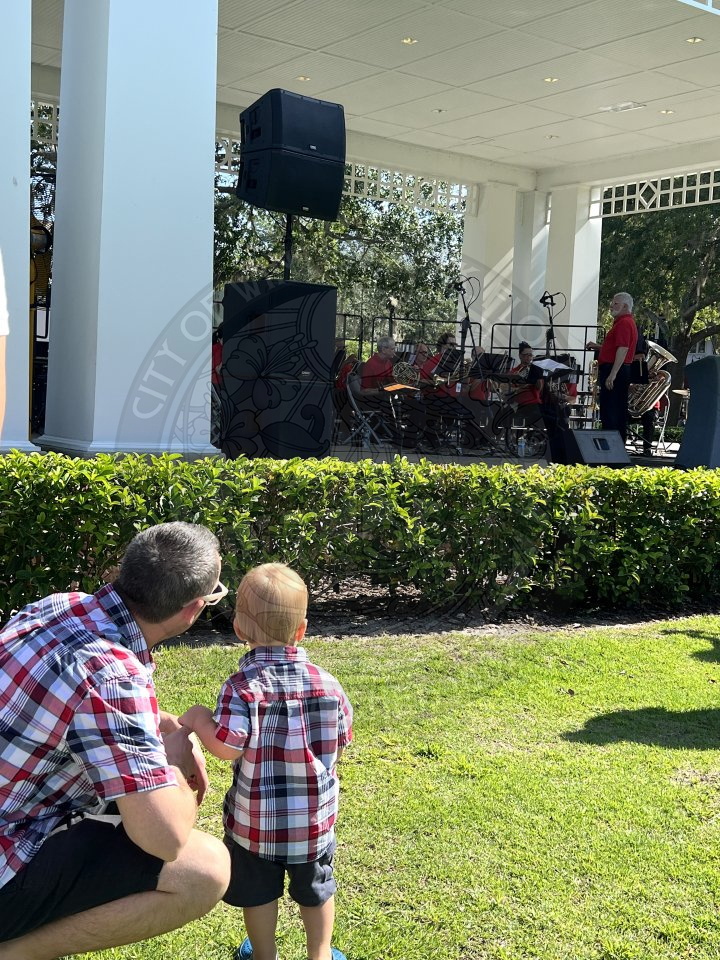 a dad and his son wearing matching plaid shirts and watching the bach fesitval perform.