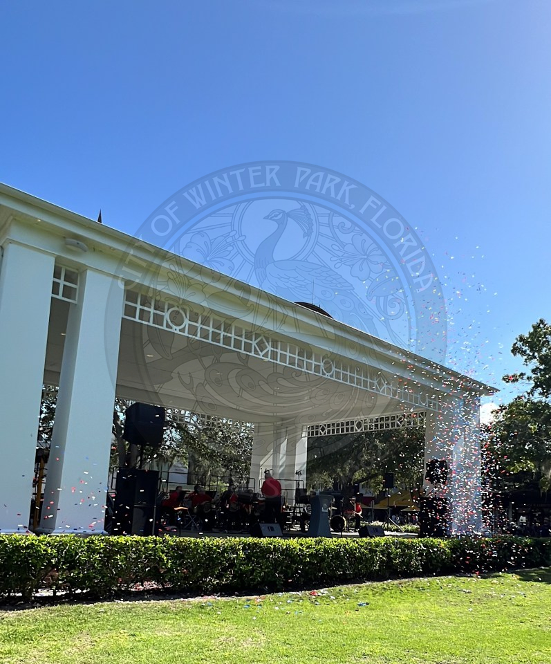 a phone of red, white and blue confetti going off in front of the Central park stage.