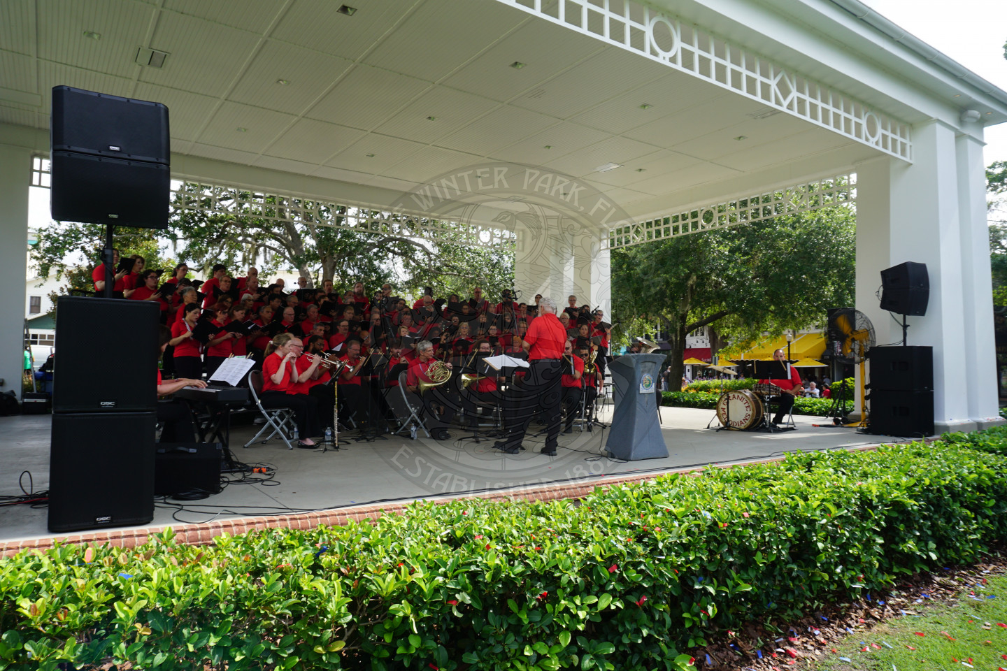 an orchestra all wearing red on the stage playing instruments.