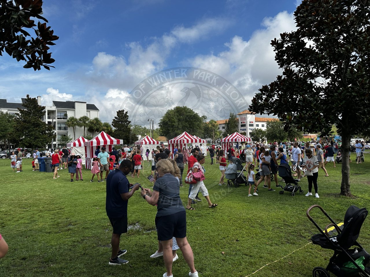 striped tents with carnival games underneath them with kids lined up to play