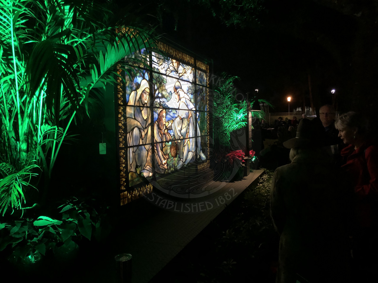 man and two women looking at a stained glass window