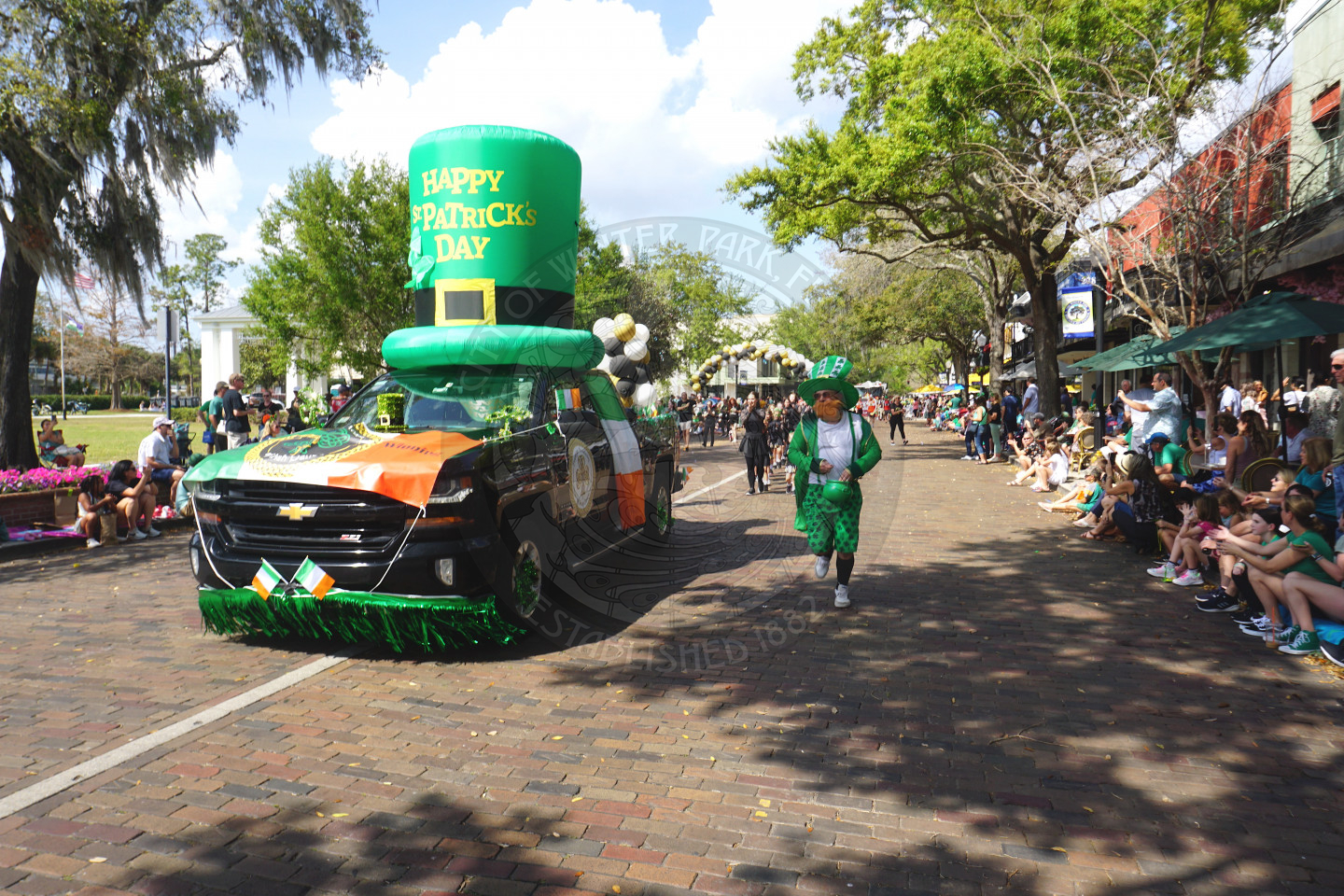 vintage truck with a big inflatable hat on the top of the truck that says "Happy St. Patrick's Day"