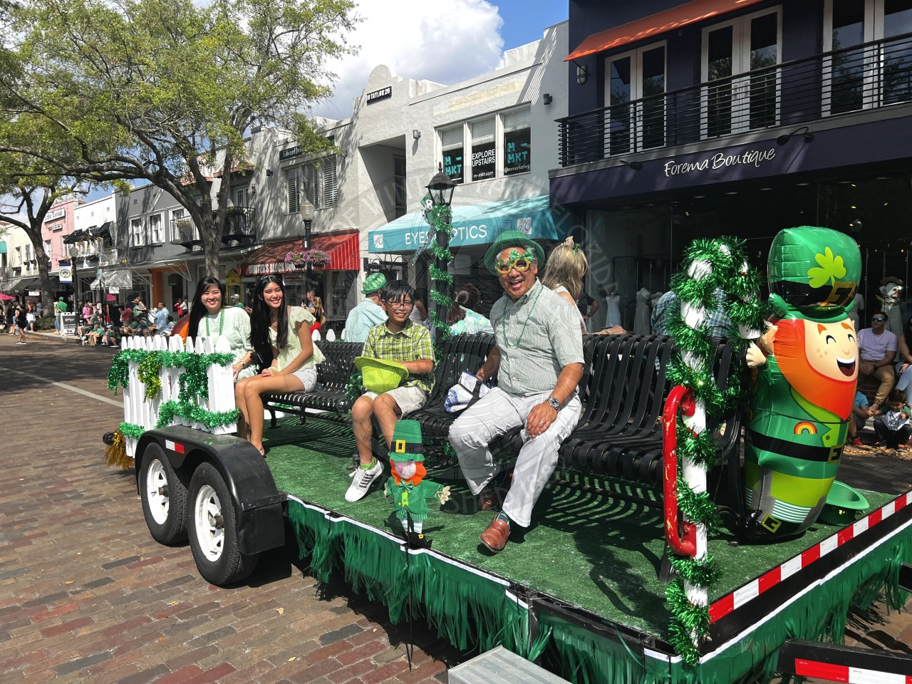 Commissioner with his wife and kids smiling while on the parade float