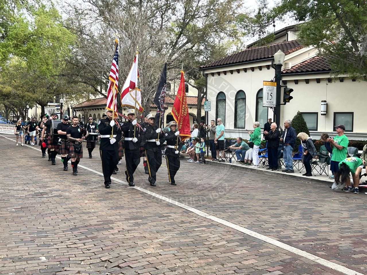 colorguard with flags marching down park avenue. Behind the colorgaurd is drum and bugle core.