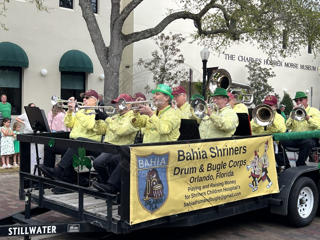 Bahian Shriners Drum &amp; Bugle Corps from Orlando, Florida sitting on a trailer riding down park avenue and playing their instruments.