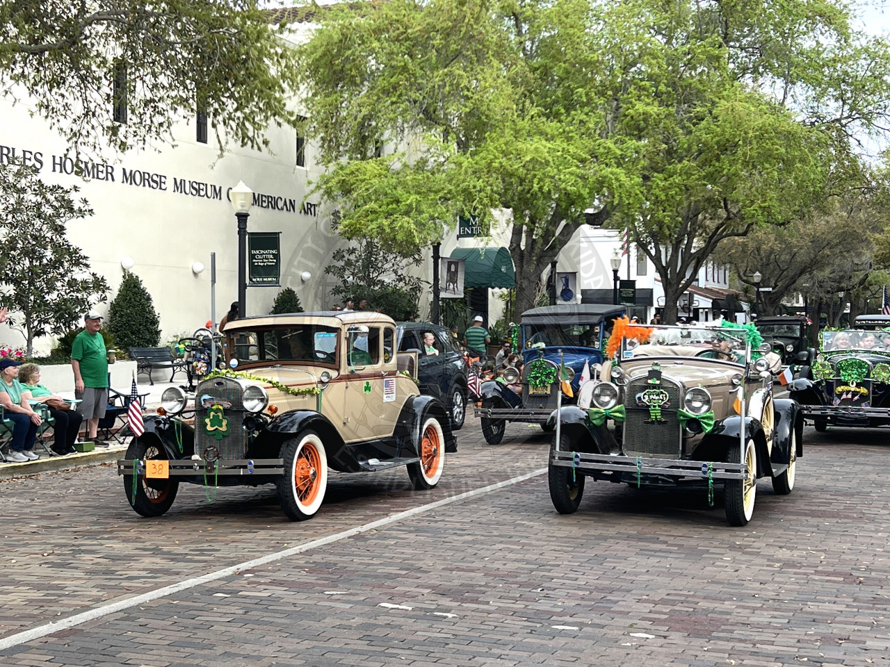 a line of old trucks driving down park avenue
