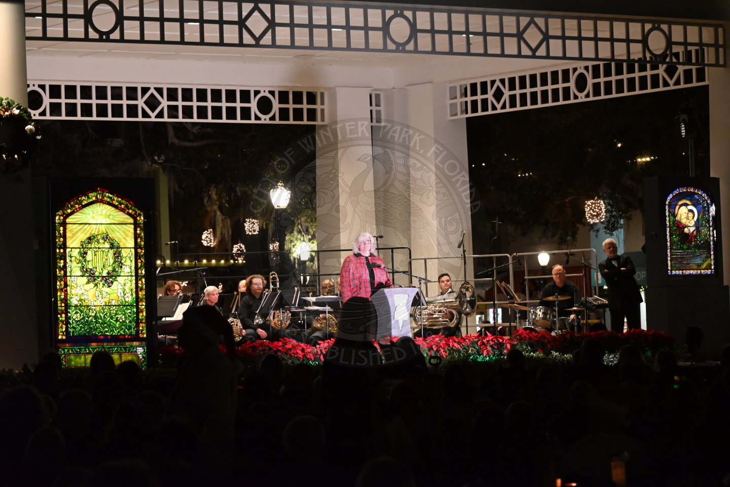A crowd of people sitting down down watching a band perform a concert.